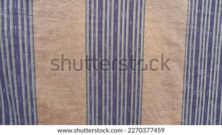 Photo of a sarong patterned with black stripes on a green background
