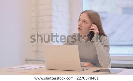 Creative Young Woman Talking on Phone to Discuss Work