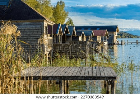 Holidays in Bavaria near Munich: Beautiful evening mood at Lake Starnberg in Kempfenhausen, Percha with wooden boat huts Royalty-Free Stock Photo #2270383549