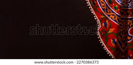 Ramadan Background with copy space - Top View of a black wooden table with Ramadan Islamic , Arabian traditional fabrics Royalty-Free Stock Photo #2270386373