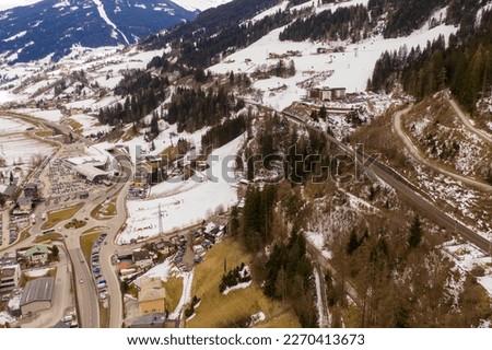 Drone photography of mountain sky slope, railway bridge going over slope and sky lifts during cloudy winter day