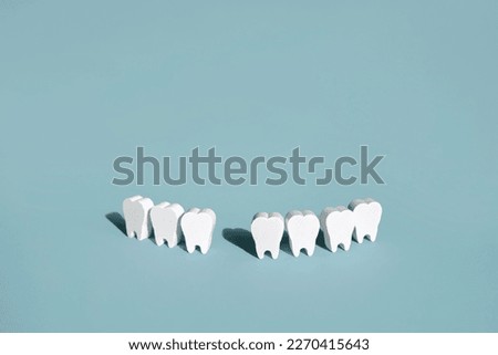 A model of teeth on a blue background with a missing front tooth . The problem of tooth loss. Daily care and oral hygiene Royalty-Free Stock Photo #2270415643