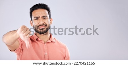 Fail, thumbs down and portrait of Asian man in studio isolated on a gray background mockup. Dislike hand gesture, emoji and face of sad male model with sign for disagreement, rejection or bad review.