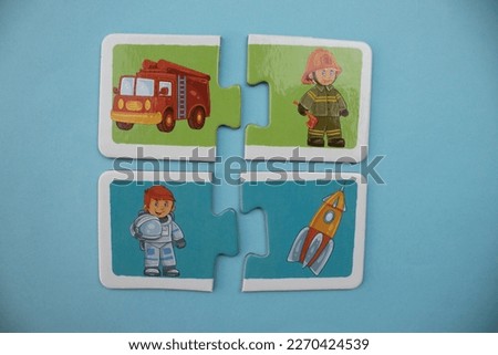 Educational puzzles with pictures of fireman, fire truck, astronaut, space, spaceship placed on a blue background.