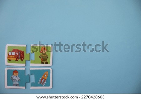 Educational puzzles with pictures of firemen, fire trucks, spaceships and astronauts placed at the lower left of the blue background.