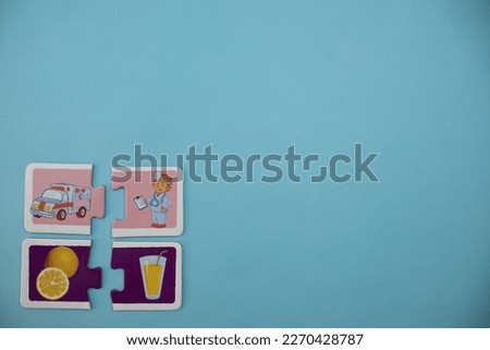 Educational puzzles with pictures of nurse, ambulance, orange and juice, placed on the lower left of the blue background.