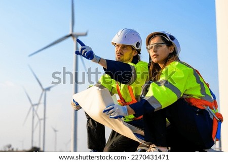 technician working outdoor at wind turbine field. Renewable energy engineer working on wind turbine projects, Environmental engineer research and develop approaches to providing clean energy sources Royalty-Free Stock Photo #2270431471