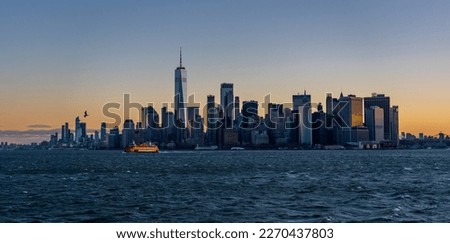 Manhattan at Sunrise with Sun reflecting on skyscrappers and Staten ISland Ferry in the foreground Royalty-Free Stock Photo #2270437803