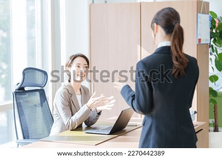 asian businesswomen talking in a office