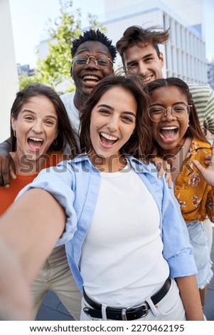 Vertical selfie young excited friends looking at camera happy. Smiling Group of people having fun together outdoors. Crazy community of college students. Modern lifestyle of multicultural people.