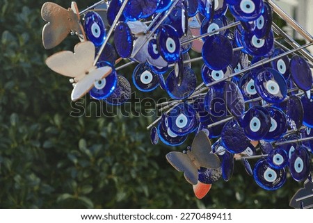 Street decorations in the form of a tree decorated with a large number of blue nazar stones from the evil eye against the blue sky