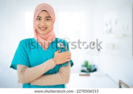 Young Muslim doctor woman over clinic background Standing confident smile.