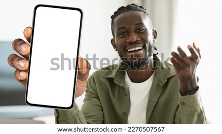 Happy Black Man With Dreadlocks Showing Big Blank Smartphone With White Screen At Camera, Cheerful African American Hipster Guy Recommending Modern Mobile App Or Website, Collage, Mockup