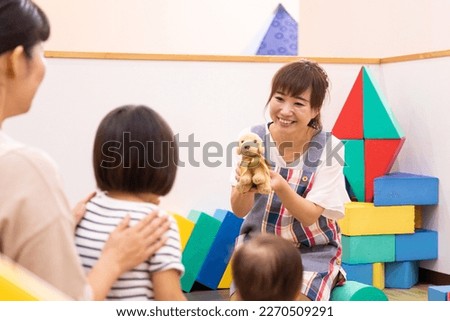 A babysitter woman working at a nursery school, daycare center, or children's center Royalty-Free Stock Photo #2270509291
