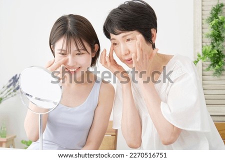 Asian mother giving skin care advice to her daughter Royalty-Free Stock Photo #2270516751