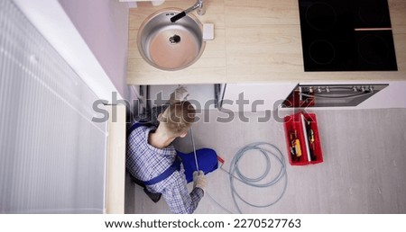 Plumber Drain Cleaning Services In Kitchen. Unclog Blocked Pipe Royalty-Free Stock Photo #2270527763