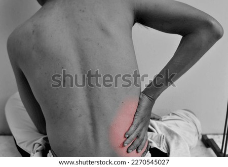 Acute pain in right hip. man holding hands to where it hurts. The background of the photo is black and white and red marks indicate the location of the pain. kidney disease