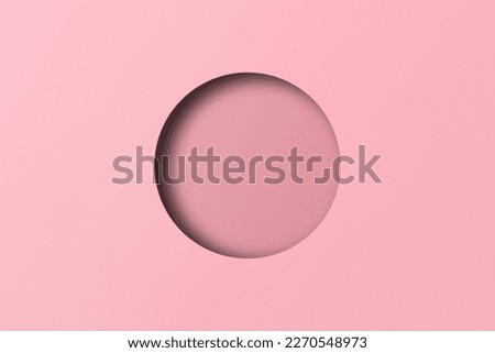 Pink paper cut into circular holes put together with light and shadow.