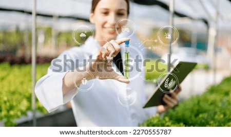 Researcher in white uniform are checking with ph strips in hydroponic farm and pH level scale graphic, science laboratory greenhouse concept. with VR icon

