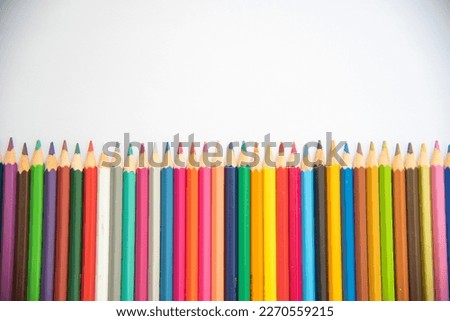 Many colored pencils on white background