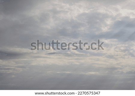A helicopter in a rainy cloudy sky covering the sun