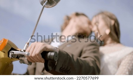 Love couple on yellow motorbike kissing each other. Action. Blurred portrait of kissing man and woman during road trip.