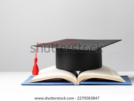 graduation cap and an open book for education day Royalty-Free Stock Photo #2270583847