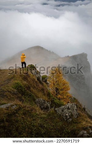 photographer and foggy landscape in high mountains