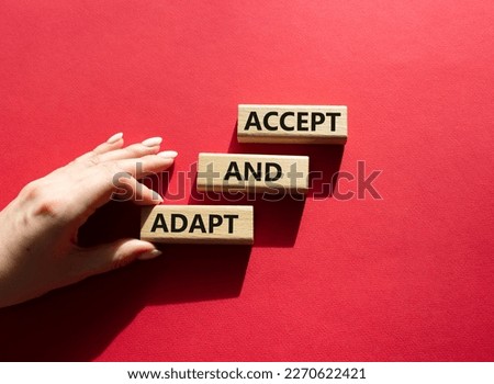Accept or adapt symbol. Wooden blocks with words Accept and adapt. Beautiful red background. Businessman hand. Business and Accept and adapt concept. Copy space.