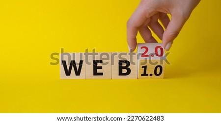 WEB 2 or 1 symbol. Businessman hand Turnes cube and changes word WEB 1.0 to WEB 2.0. Beautiful yellow background. Business and WEB concept. Copy space