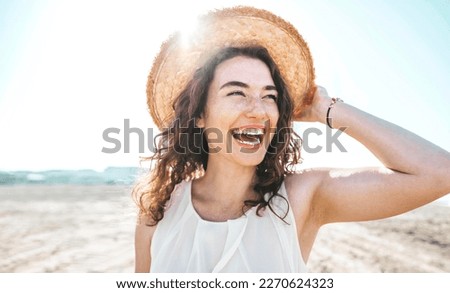 Happy beautiful young woman smiling at the beach side - Delightful girl enjoying sunny day out - Healthy lifestyle concept with female laughing outside  Royalty-Free Stock Photo #2270624323