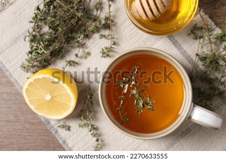 Aromatic herbal tea with thyme, honey and lemon on wooden table, top view Royalty-Free Stock Photo #2270633555