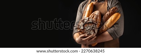 Man holding breas in his hands. Different types of bread. bakery products on a dark background. Long banner format. Royalty-Free Stock Photo #2270638245