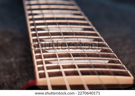 Macro low light shot of electric guitar fretboard