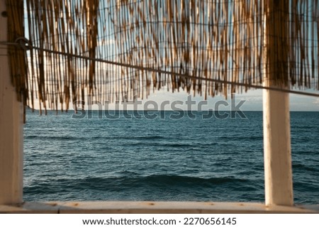 Cozy terrace on the beach, idyllic view of the seashore. Tropical summer vacation concept.