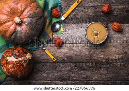 Rustic style pumpkins and soup with seeds and ground cherry on wood. Autumn Season food photo