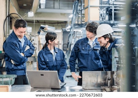 Factory staff discussing over a computer