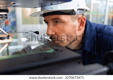 An engineer using optical micrometer quality checking micro part and close up look