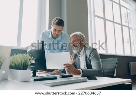 Two confident men doing some paperwork while spending time in the office together Royalty-Free Stock Photo #2270684657