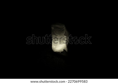 Minimalist photo concept of rounded single tissue paper illuminated with handphone flash.