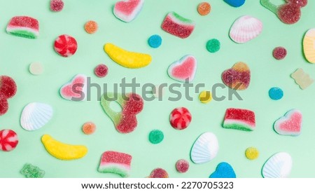 Colorful jelly candies on green background. Top view, flat lay Royalty-Free Stock Photo #2270705323
