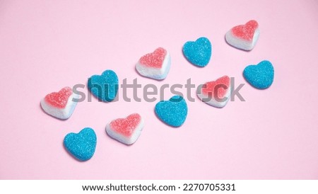 Colorful candies in the shape of hearts on a pink background Royalty-Free Stock Photo #2270705331