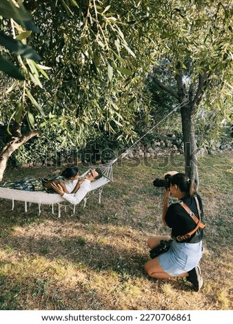 Girl photographer photographs a woman lying on a man in a hammock