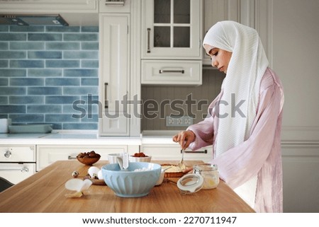Young muslim woman in hijab preparing breakfast in kitchen at home. Arab woman Baking Royalty-Free Stock Photo #2270711947