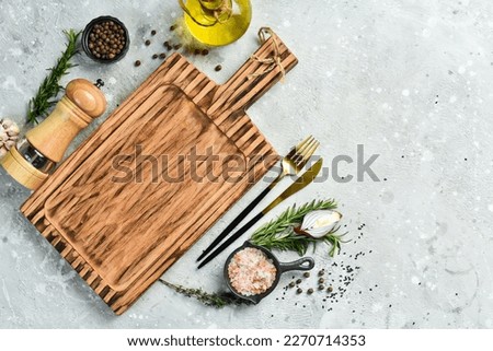 Cooking banner. Kitchen wooden board and spices on concrete table. Free space for text. Rustic style.