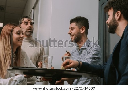 Four inter-generational group of people having fun conversation and smiling while working together on a new project at the office. Low angle view photo