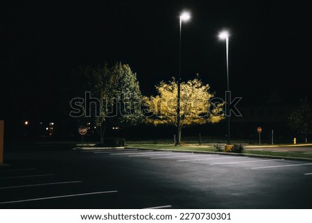 Empty parking lot lit by street lights. Royalty-Free Stock Photo #2270730301