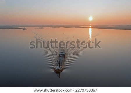 Aerial from a freighter cruising on a frisian lake in the Netherlands at sunset