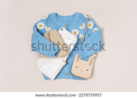 Cute blue knitted children's jacket with trousers, hat and bag. Stylish kids clothes for spring, autumn or winter. Fashion outfit. Flat lay, top view   Royalty-Free Stock Photo #2270739957