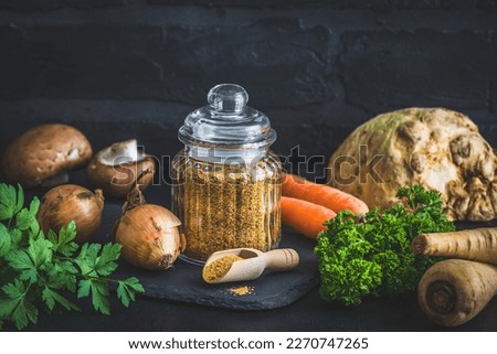 Homemade vegetable broth powder, organic vegetable stock, with raw vegetables on black background, copy space
